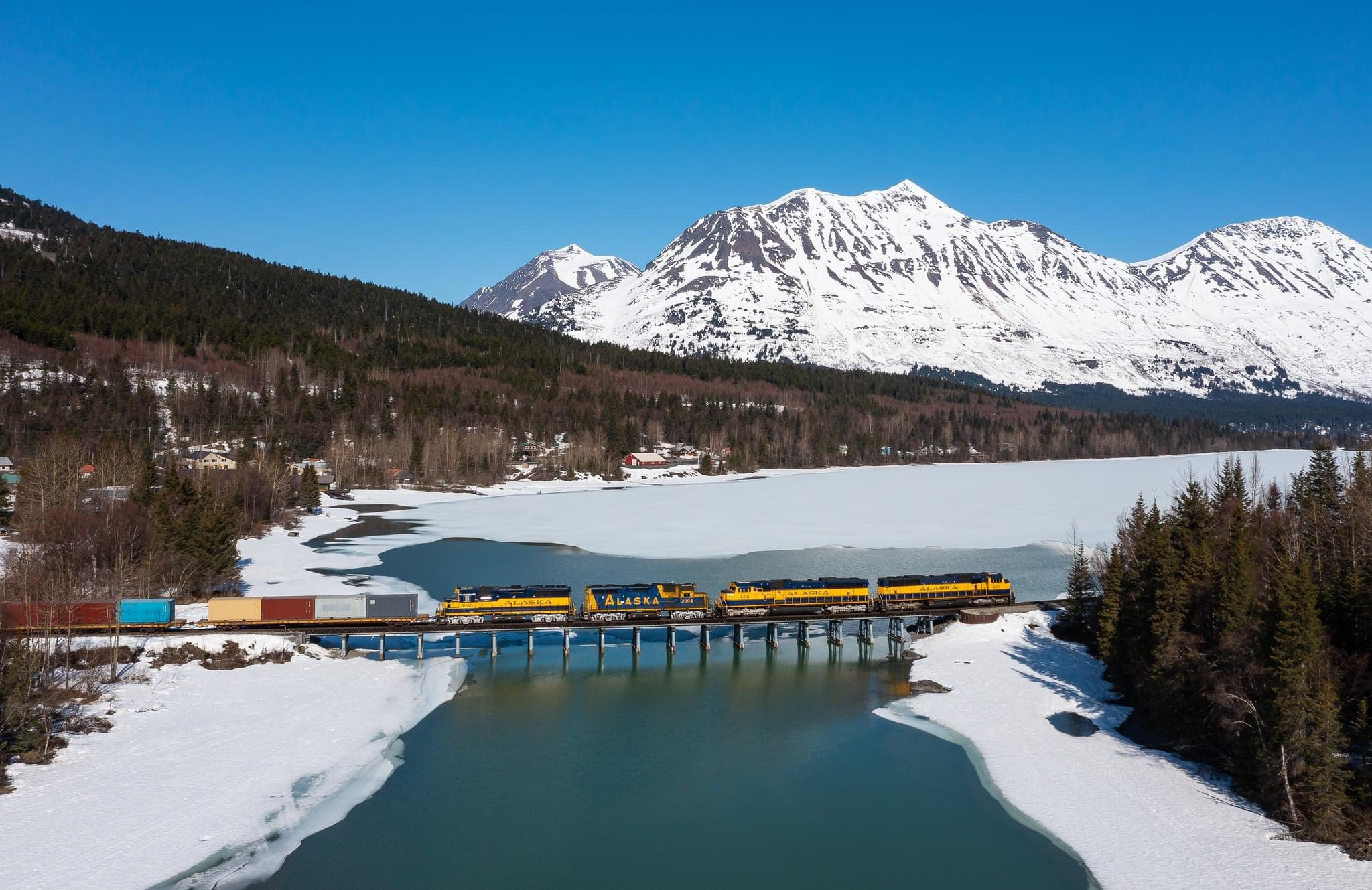 A northbound freight from Seward to Anchorage crosses the bridge between Upper and Lower Trail Lakes on a beautiful day.